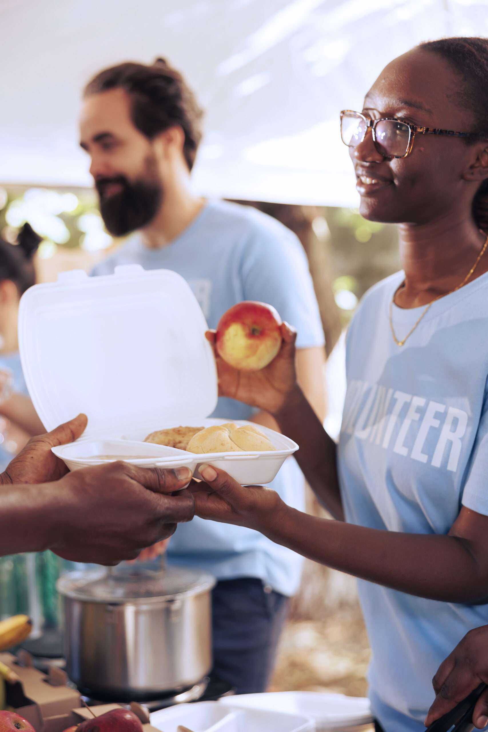 Nonprofit volunteers distributing meals and fresh food at a community service event